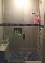 Cabine de douche en céramique grise et bleue avec portes en verre
